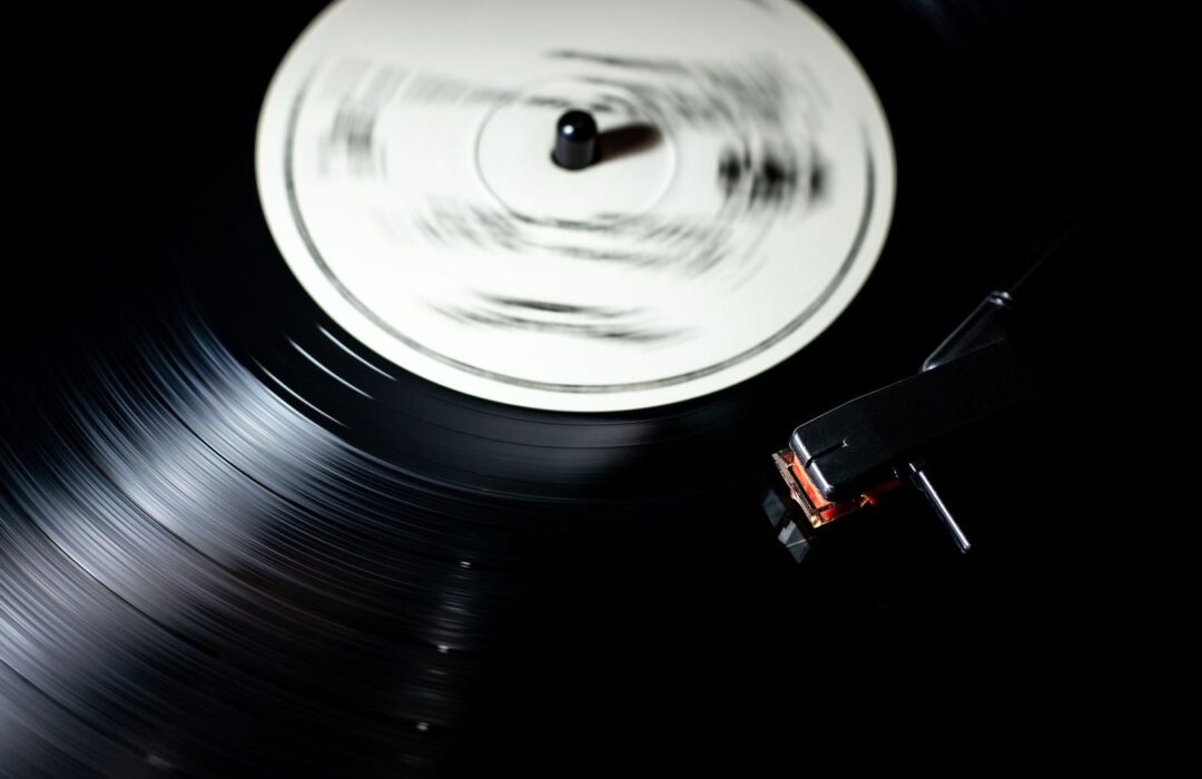 Nærbillede af en roterende vinylplade og pickup på en pladespiller